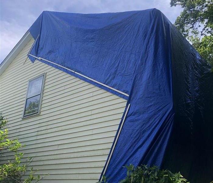 A tarped roof after storm damages