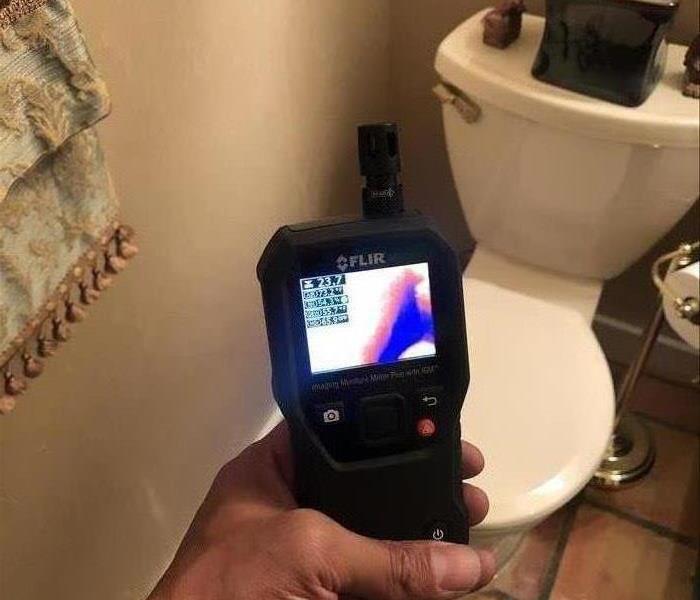 A SERVPRO professional documenting the damages done by a toilet leak
